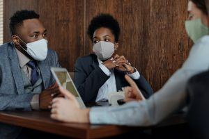 A group of people wearing masks and discussing